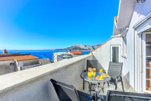 a balcony with a table and chairs and a view of the ocean at OMIŠ Dream house in Omiš
