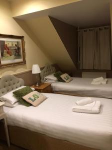 dwa łóżka z ręcznikami na nich w pokoju w obiekcie Arden House NEC Birmingham w mieście Bickenhill
