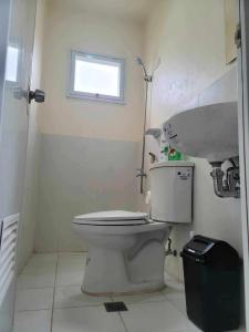 a bathroom with a toilet and a sink at New Tropical Inspired Home in Cagayan de Oro