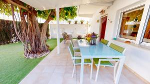 un patio con mesa, sillas y un árbol en Apartamento Net by Family Homes, en Denia