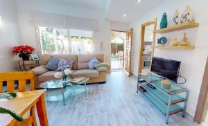 un soggiorno con un divano e una TV di Apartamento Net by Family Homes a Denia