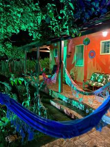 a house with a hammock in front of it at Pousada Jardim de Minas in Serra do Cipo