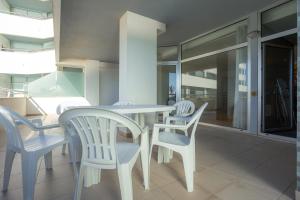 a dining room with white chairs and a table at Buarcos Ocean Village in Buarcos