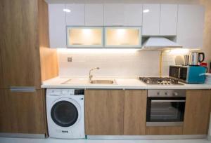 a kitchen with a sink and a washing machine at Modern Studio In Resortz Residence - Arjan in Dubai