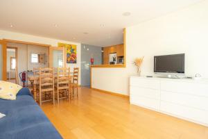a living room with a television and a dining room at Buarcos Ocean Village in Buarcos