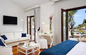 a bedroom with a bed and a living room at La Plage Resort in Taormina