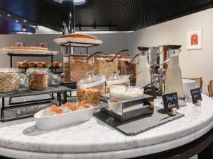 a buffet line with various food items on a counter at B&B Hotel Quarto d'Altino in Quarto dʼAltino