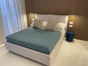 a bedroom with a large bed with blue sheets and pillows at La Finestra sul Mare Modern Apartment in Giardini Naxos