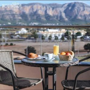 a table with a cup of coffee and a basket of fruit at Nou Avenida in Gata de Gorgos