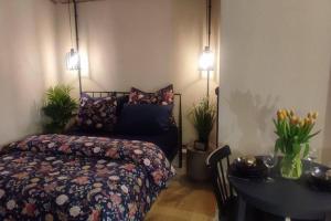 a bedroom with a bed and a table and lights at Przytulne studio z parkingiem in Katowice