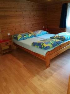 Bett in einem Zimmer mit Holzboden in der Unterkunft Runatsch 133 A in Zernez