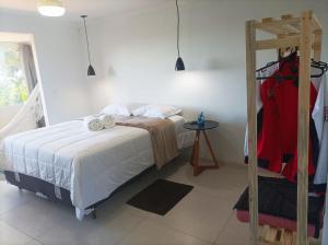a bedroom with a bed and racks of clothes at Sítio Werly in Domingos Martins