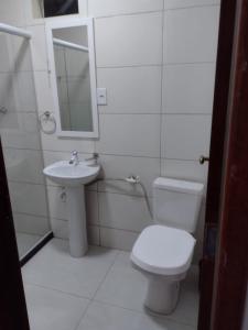 a white bathroom with a toilet and a sink at Sítio Werly in Domingos Martins