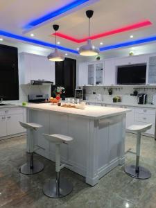 una cocina con una gran isla blanca con taburetes en Villa Ada Luxury Retreat, en Juan Dolio