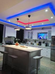cocina con luces rojas y azules en el techo en Villa Ada Luxury Retreat, en Juan Dolio