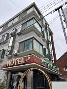 un bâtiment avec un panneau de motel devant lui dans l'établissement Swiss Motel, à Mokpo