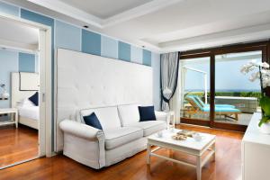 ein Wohnzimmer mit einem weißen Sofa und einem Tisch in der Unterkunft La Plage Resort in Taormina