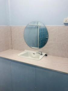 een badkamer met een wastafel en een spiegel op een aanrecht bij SS GUESTHOUSE in Ban Map Prasoe