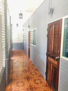 a hallway with an orange tile floor and an open door at SS GUESTHOUSE in Ban Map Prasoe