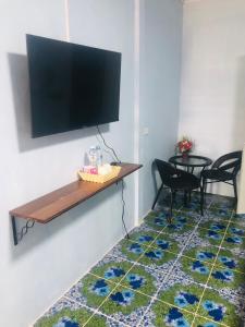 sala de estar con TV de pantalla plana en la pared en SS GUESTHOUSE, en Ban Map Prasoe