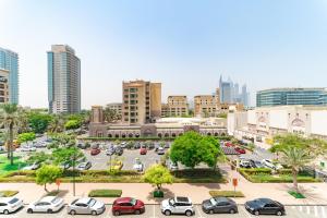 a city with cars parked in a parking lot at Beautifully furnished 3BDR in Al Sidir Greens in Dubai