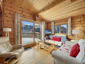 a living room with furniture and a large window at CH201 Chalet 6 Pers in Les Carroz d'Araches