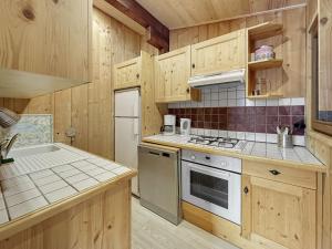 uma cozinha com armários de madeira e um forno com placa de fogão em CH201 Chalet 6 Pers em Les Carroz d'Arâches