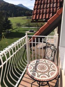 a balcony with a table and a white fence at Apartmaji Misotič in Gozd Martuljek +4 photos