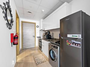 eine Küche mit einem Kühlschrank aus Edelstahl und einem Geschirrspüler in der Unterkunft Spacious Studio With A Sofa Bed In JVC in Dubai