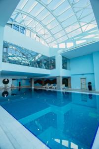 a large swimming pool with a glass ceiling at JRW Welmond Hotel in Batumi