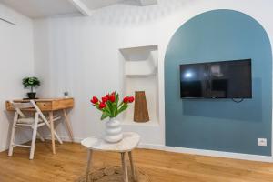 a living room with a vase with red flowers in it at Studio cozy centre avec Parking in Grasse