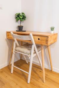 a wooden desk with a chair and a plant on it at Studio cozy centre avec Parking in Grasse