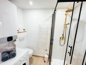 a white bathroom with a shower and a toilet at Studio cozy centre avec Parking in Grasse