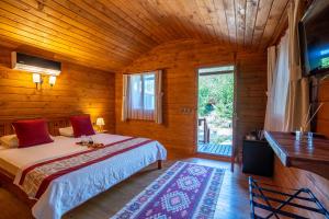 een slaapkamer met een bed in een houten kamer bij Eden Bungalows and Beach in Koycegiz