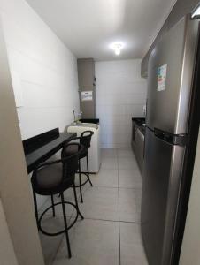a small kitchen with a table and a refrigerator at APARTAMENTO JOÃO PESSOA BESSA in João Pessoa