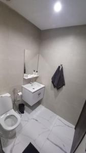 a white bathroom with a toilet and a sink at MEHDIA PLAYA in Kenitra