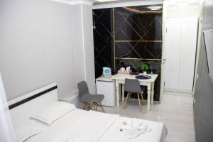 1 dormitorio con 1 cama, mesa y sillas en AG Hotel, en Almaty