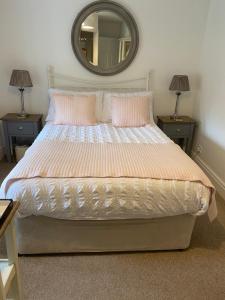 a bedroom with a bed with two lamps and a mirror at Rye Flatt Bed and Breakfast in Colne