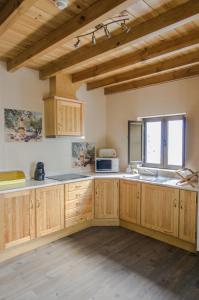a large kitchen with wooden cabinets and a window at Oliveira Country House in Figueira e Barros