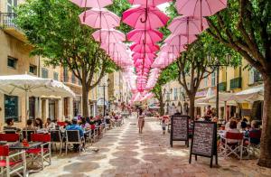 a street with pink umbrellas hanging from trees at Studio cozy centre avec Parking in Grasse