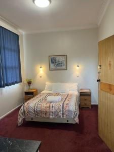 a bedroom with a bed with two night stands and a window at Oasis Motel - waiouru in Waiouru