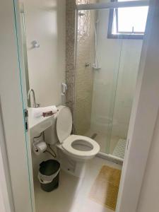 a small bathroom with a toilet and a shower at MDJ Suítes in Cabo Frio