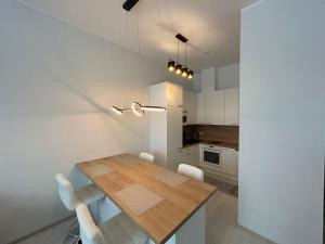 una cucina con un tavolo in legno e mobili bianchi di Tamula Lake Loft apartment, Võru, Võru County a Võru