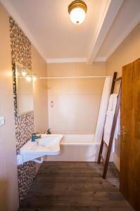 a bathroom with a bath tub and a sink and a bath tub at Oliveira Country House in Figueira e Barros