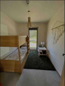 a room with a bunk bed and a table at Peaceful holiday house Pāvilosta in Pāvilosta