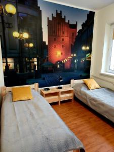 sypialnia z dwoma łóżkami i dużym malowidłem miejskim w obiekcie Szkolne Schronisko Mlodziezowe w Olsztynie w Olsztynie