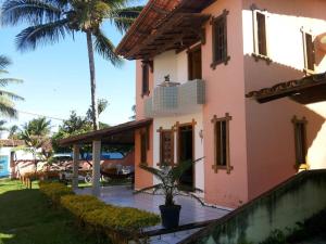 ein Haus mit einer Palme davor in der Unterkunft Casa de Praia piscina -60 m da praia, 3/4 Cond. in Olivença