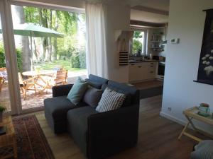 a living room with a couch and a table and a kitchen at Ferienwohnung Alte Fehnapotheke, 95144 in Rhauderfehn