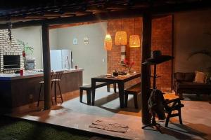 eine Küche und ein Esszimmer mit einem Tisch in einem Zimmer in der Unterkunft Casa de Praia piscina -60 m da praia, 3/4 Cond. in Olivença