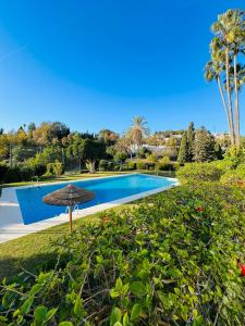 una sombrilla sentada junto a una piscina en Paradis sur le Golf de le Quinta avec accès direct à la piscine, en Marbella